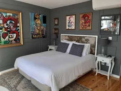 a bedroom with a white bed and paintings on the wall at Casas do Loureiro in Porto