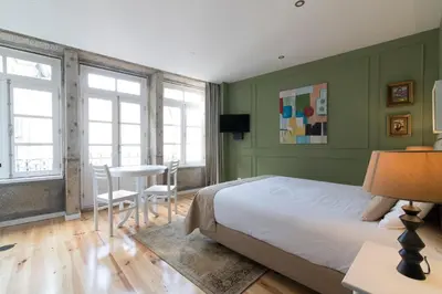 a bedroom with a bed and a table and chairs at Casas do Loureiro in Porto