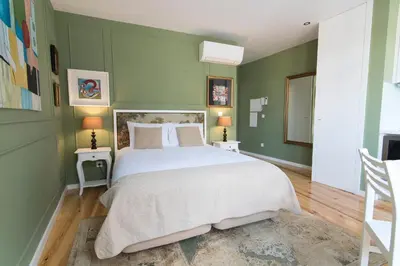 a bedroom with a large bed with green walls at Casas do Loureiro in Porto