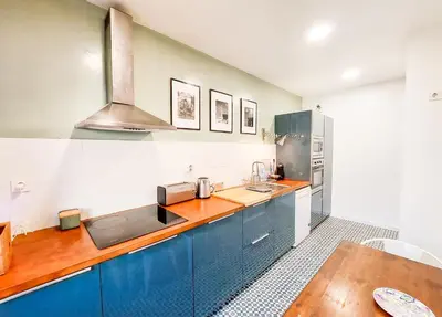 a kitchen with blue cabinets and a counter top at Bluetile Sol Apartment in Porto