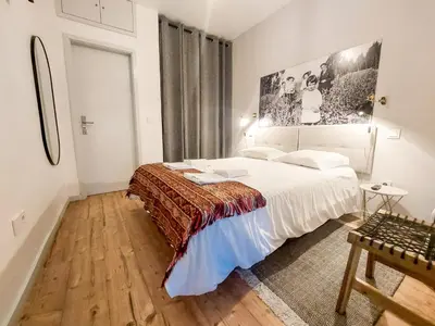a bedroom with a white bed and wooden floors at Bluetile Sol Apartment in Porto