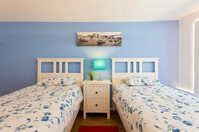 two beds in a bedroom with blue walls at Oporto Blue Picaria - Unique Citycenter Apartment in Porto