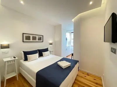a bedroom with a bed and a flat screen tv at MyStay Porto Centro in Porto