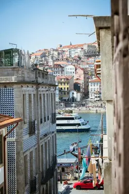 a view of a city with a river and boats at Porto Views & Wines by Porto City Hosts in Vila Nova de Gaia