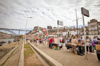 a crowd of people standing on a sidewalk next to a river at Porto Views & Wines by Porto City Hosts in Vila Nova de Gaia