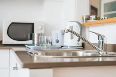 a kitchen counter with a sink and a microwave at GuestReady - Modern stay in downtown Porto in Porto