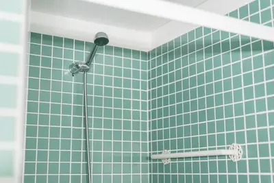 a shower with green tile on a wall at GuestReady - Modern stay in downtown Porto in Porto