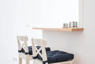 two white chairs sitting next to a shelf at GuestReady - Modern stay in downtown Porto in Porto