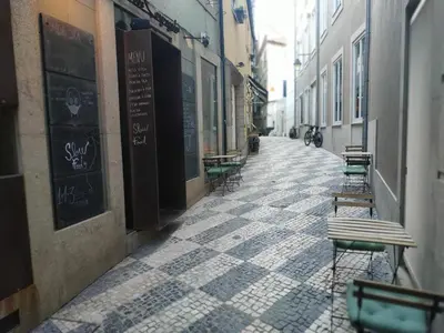 an empty alley with tables and benches on a street at ML Apartments Central Aliados in Porto