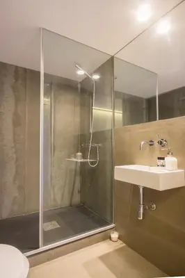 a bathroom with a shower with a sink and a glass shower door at OHH - Mouzinho Deluxe Apartment in Porto