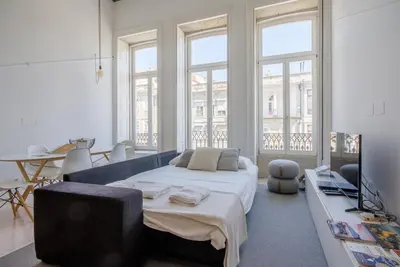 a bedroom with a large bed in a room with windows at OHH - Mouzinho Deluxe Apartment in Porto