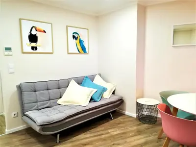 a couch in a living room with paintings on the wall at Porto Ville Touring in Porto