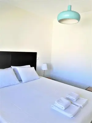 a bedroom with a white bed with towels on it at Porto Ville Touring in Porto