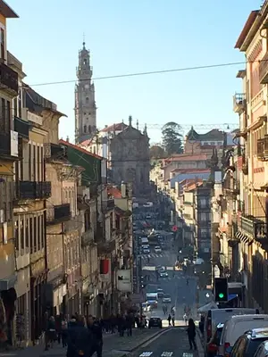 a busy city street with a clock tower in the distance at Invictus Place in Porto