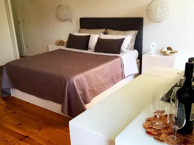 a bedroom with a bed and two tables with wine glasses at Invictus Place in Porto