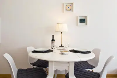 a white table with chairs and a bottle of wine at Porto Terrace Apartment in Porto