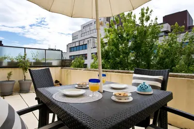 a table with food and an umbrella on a balcony at Porto Terrace Apartment in Porto