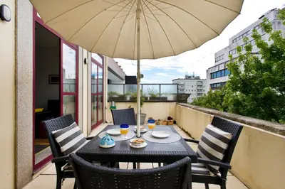 a table and chairs with an umbrella on a balcony at Porto Terrace Apartment in Porto
