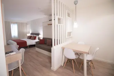 a small room with a bed and a table and chairs at Almada Wine House - Tourism Apartments in Porto