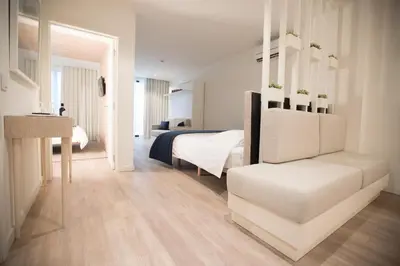 a white bedroom with a bed and a white chair at Almada Wine House - Tourism Apartments in Porto