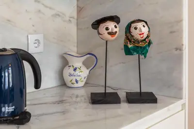 a counter with statues of clowns and a vase at Home Alegria in Porto