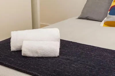a stack of paper towels sitting on a bed at Home Alegria in Porto