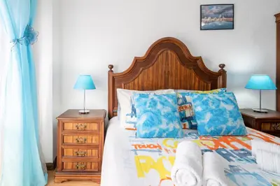 a bedroom with a bed with a blue comforter at Apartment Rustic Oporto in Porto