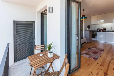 a kitchen and a dining room with a wooden table at Sunny Home in Porto