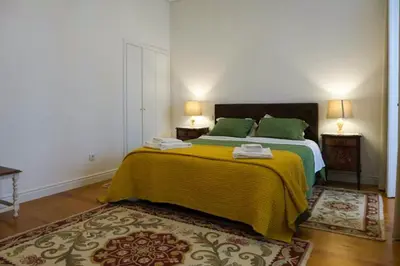a bedroom with a bed with green sheets and green pillows at Casa Velha Guesthouse in Porto
