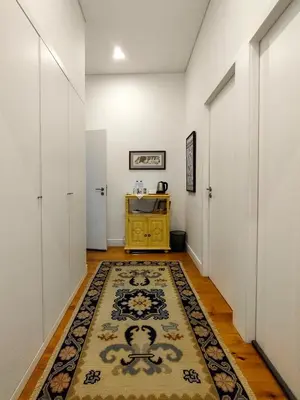 a hallway with a rug and a yellow cabinet at Casa Velha Guesthouse in Porto