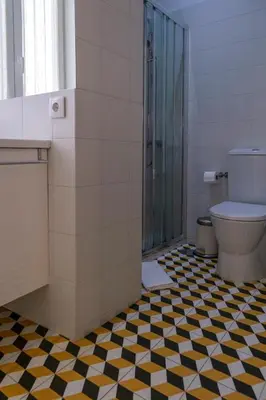 a bathroom with a black and white checkered floor at Casa Velha Guesthouse in Porto