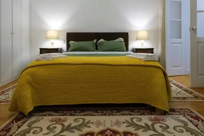 a bedroom with a large bed with a yellow blanket at Casa Velha Guesthouse in Porto