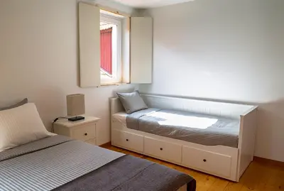 a small bedroom with a bed and a window at Casa da Oliveira in Porto