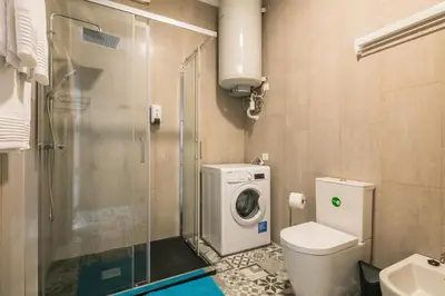 a bathroom with a toilet and a washing machine at Merc Porto Ribeira's Up place in Porto