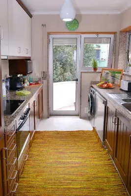 a kitchen with a yellow rug on the floor at Apartamento Porto Centro in Porto