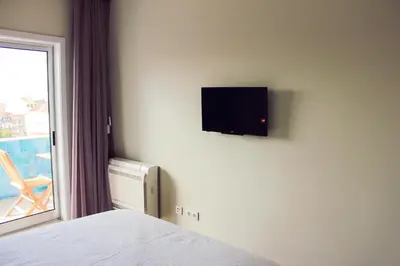 a bedroom with a bed and a tv on a wall at Apartamento da Lapa in Porto