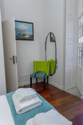 a room with a green chair and a mirror at Bonjardim Terrace in Porto
