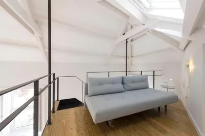 a bench in a room with white ceilings at BmyGuest - Porto Design Central Apartment in Porto