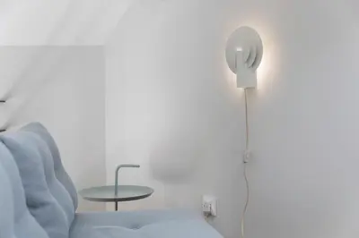 a room with a chair and a table and a floor lamp at BmyGuest - Porto Design Central Apartment in Porto