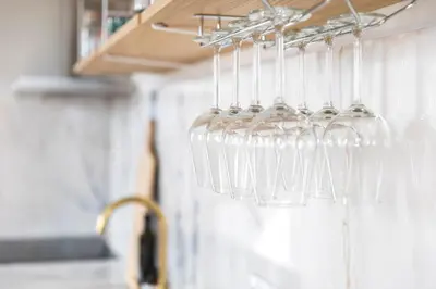 a bunch of wine glasses hanging from a rack in a kitchen at BmyGuest - Porto Design Central Apartment in Porto