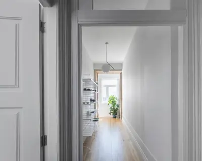 a hallway with a door leading to a room with white walls at BmyGuest - Porto Design Central Apartment in Porto