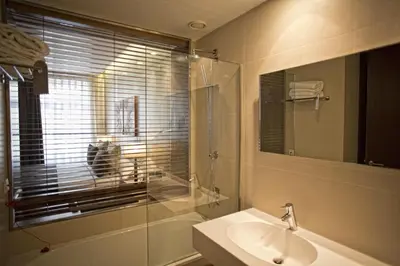 a bathroom with a sink and a toilet and a mirror at Hotel Carris Porto Ribeira in Porto