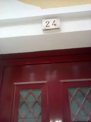 a red door with the number above it at Casinha Miradouro in Vila Nova de Gaia