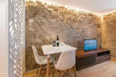 a dining room with a table and chairs and a wall at GuestReady - The New Yellow Ledbetter in Porto