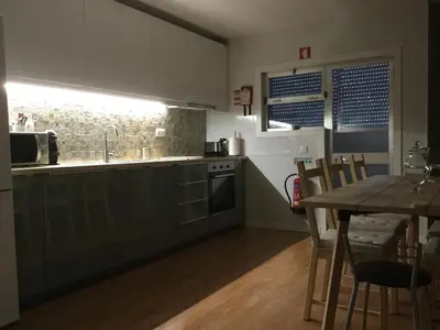 a kitchen with a table and a sink and a counter at My Portugal for All - Oporto Flat in Vila Nova de Gaia