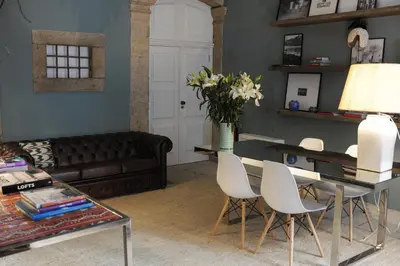 a living room with a couch and a table with white chairs at Mo House in Porto