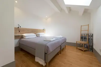 a bedroom with a bed with a wooden headboard at Bom-Jardim Trindade in Porto
