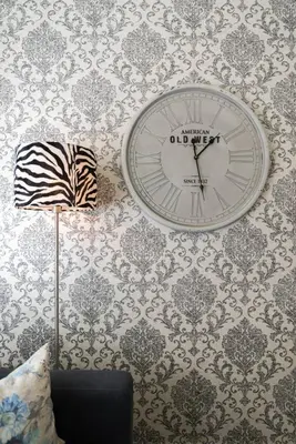 a clock is hanging on a wall with wallpaper at Porto Downtown Apartment in Porto