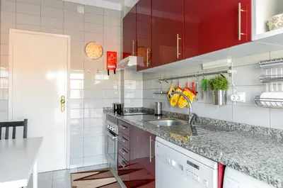 a kitchen with a sink and red cabinets at Porto Downtown Apartment in Porto