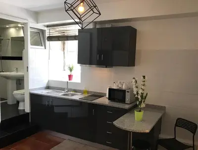 a kitchen with black cabinets and a sink and a microwave at Firmeza 358 studios - street level in Porto